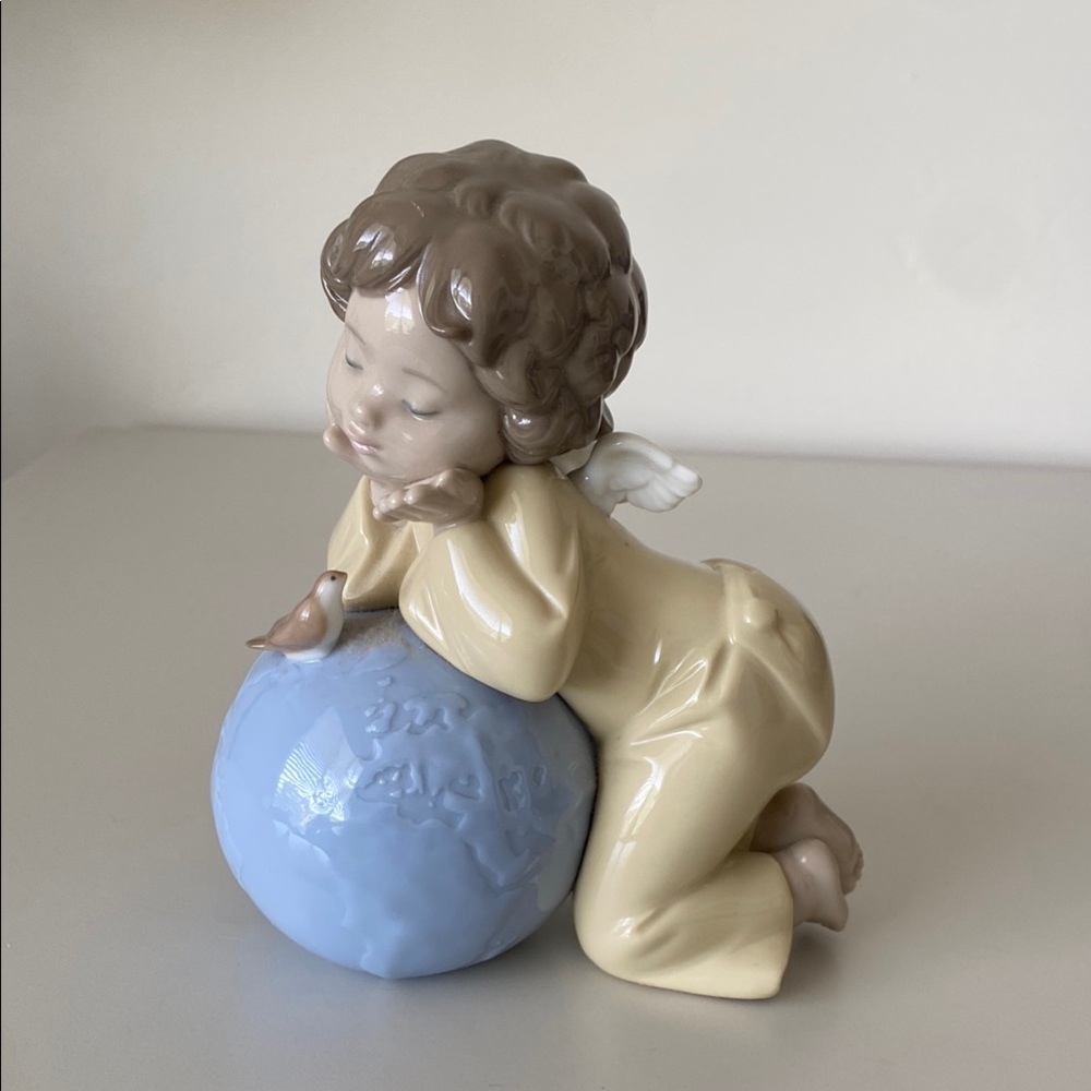 NAO by Lladro girl angel, leaning over a globe with bird